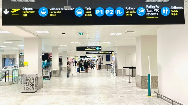 Panneaux dans le hall d’arrivée de l’aéroport de Nice : taxis, parkings et zone VTC réservés